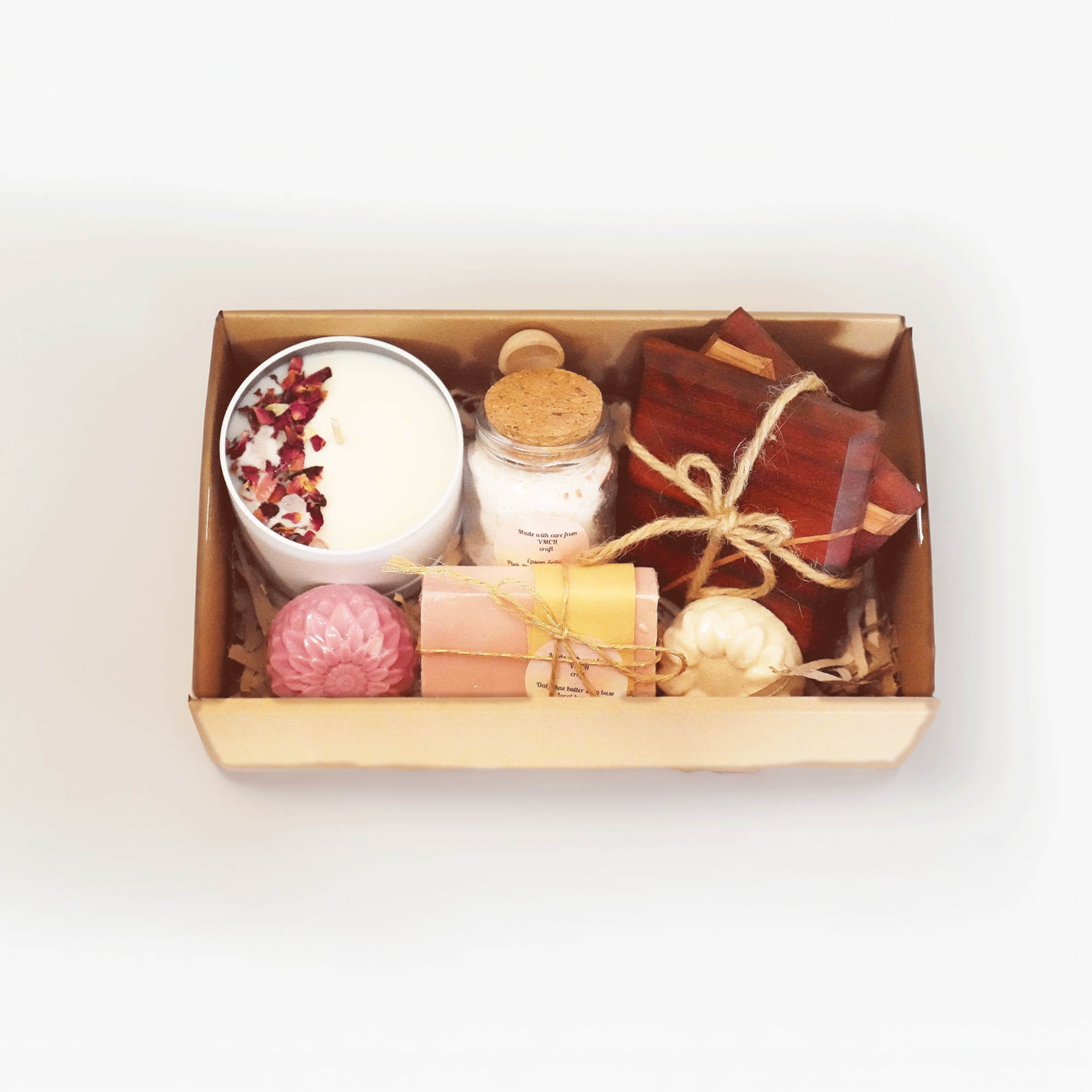 Hamper with handmade items including a candle, bath salts, soaps and wooden coasters